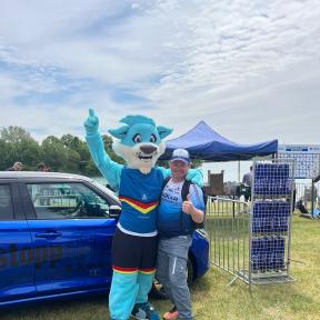 Das Maskottchen Trinity mit DTU Mitarbeiter und SUZUKI Auto