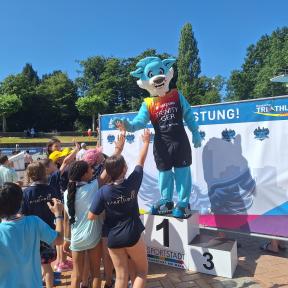Das Maskottchen Trinity auf dem Podest beim Schultriathlon in Frankfurt