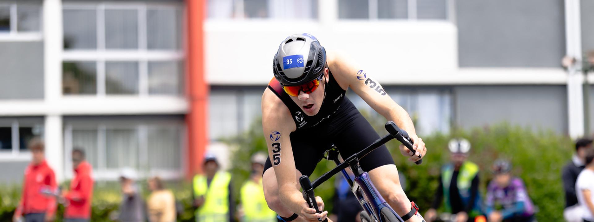 Ein Triathlet fährt konzentriert eine enge Kurve auf dem Rennrad