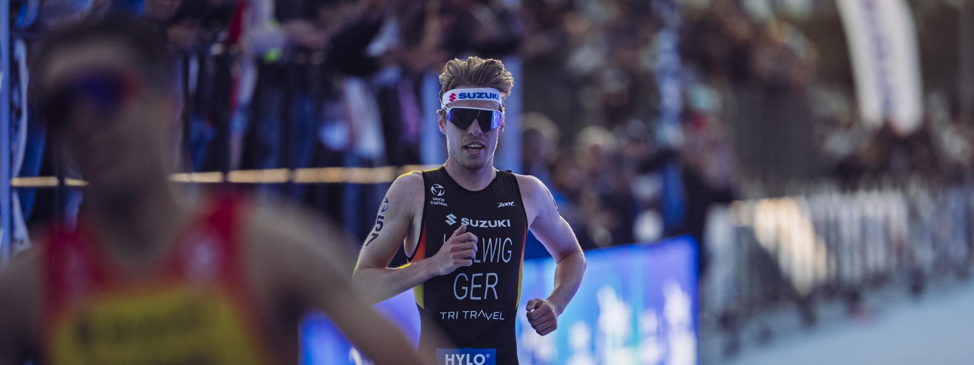 Ein Triathlet läuft über den Zielteppich ins Ziel eines Rennens