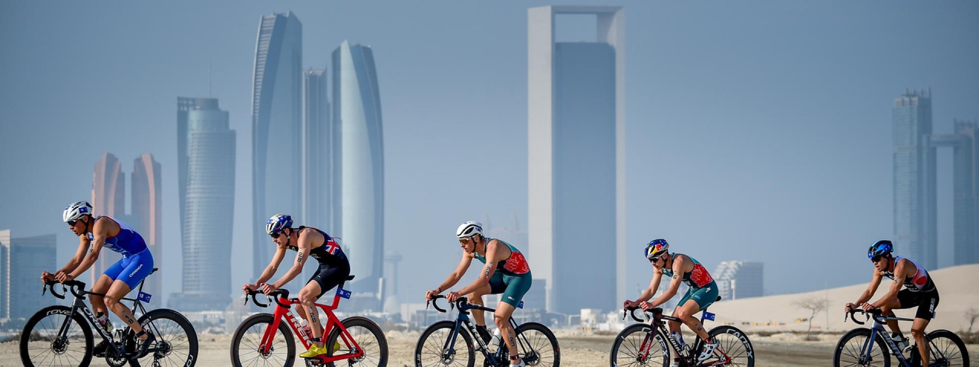 Elite-Triathleten auf Radstrecke vor Abu Dhabi Skyline