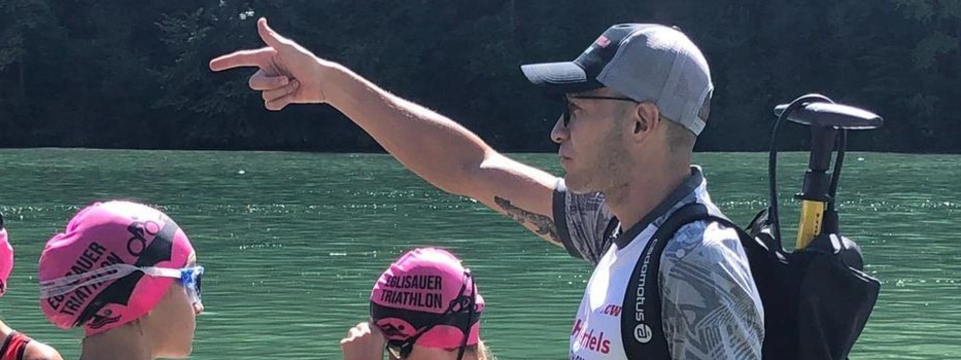 Trainer am Wasser mit jungen Athleten