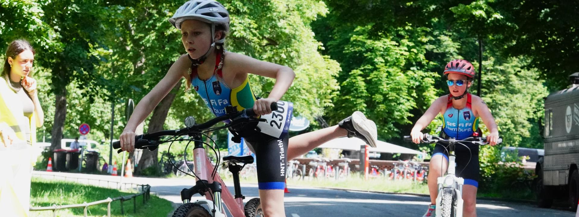 Mädchen steigt am Beginn der Wechselzone vom Fahrrad 
