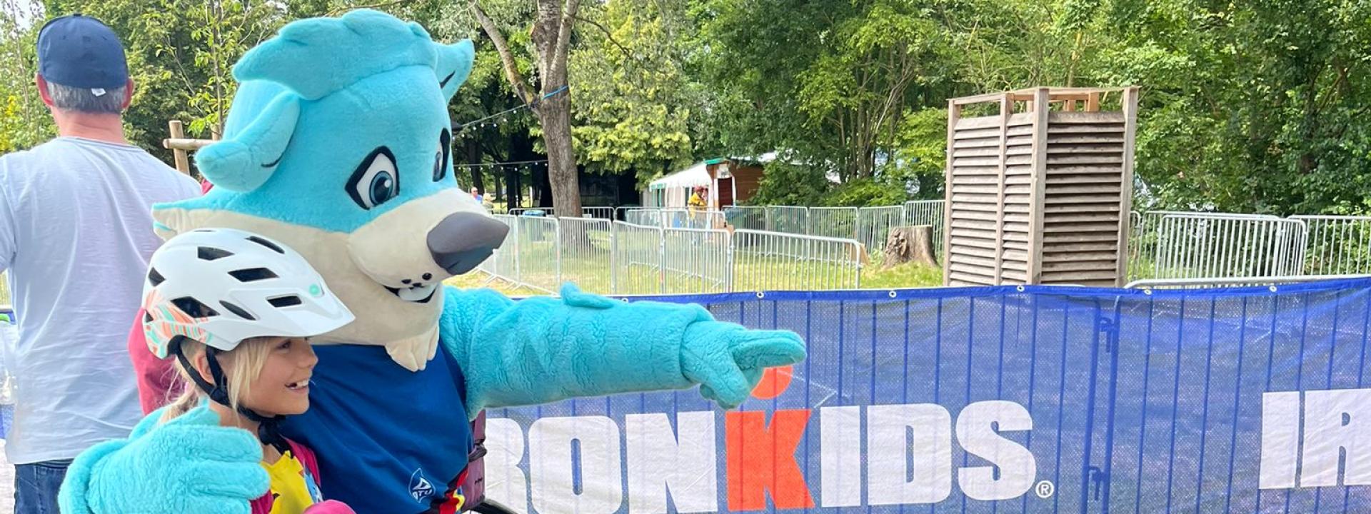 Das Maskottchen Trinity mit Kind und Fahrrad