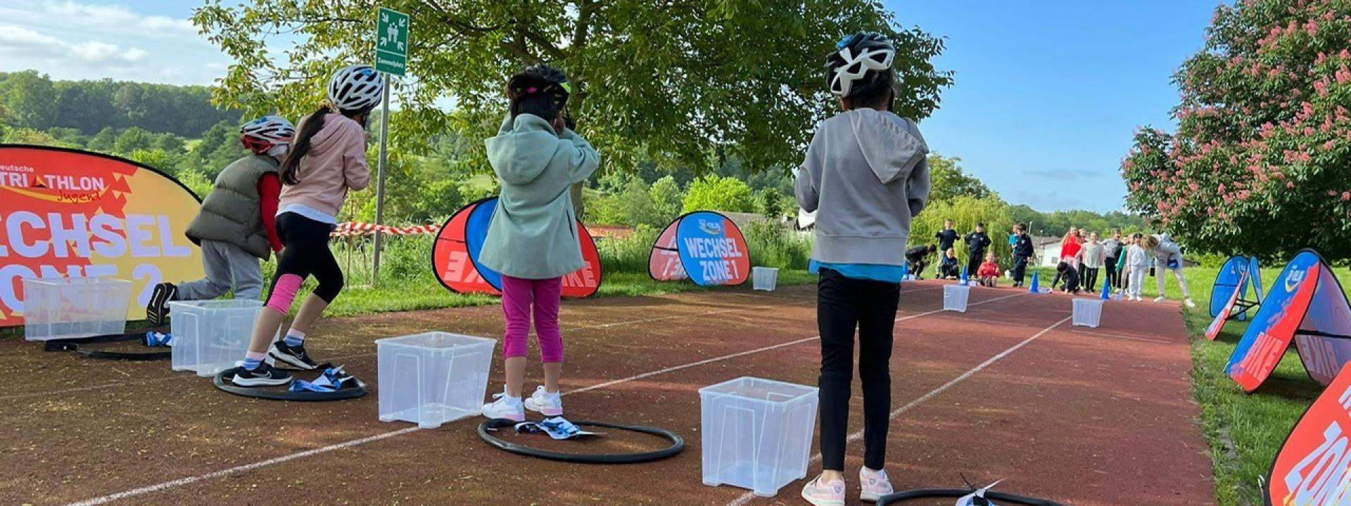 Kinder beim Schulsport Triathlon auf der Tartanbahn