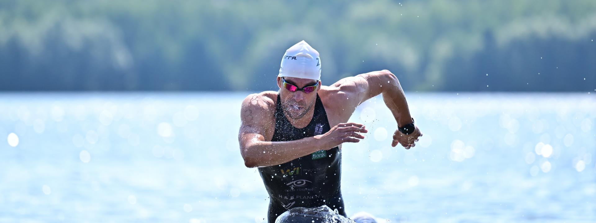 Athlet kommt aus dem See gelaufen 