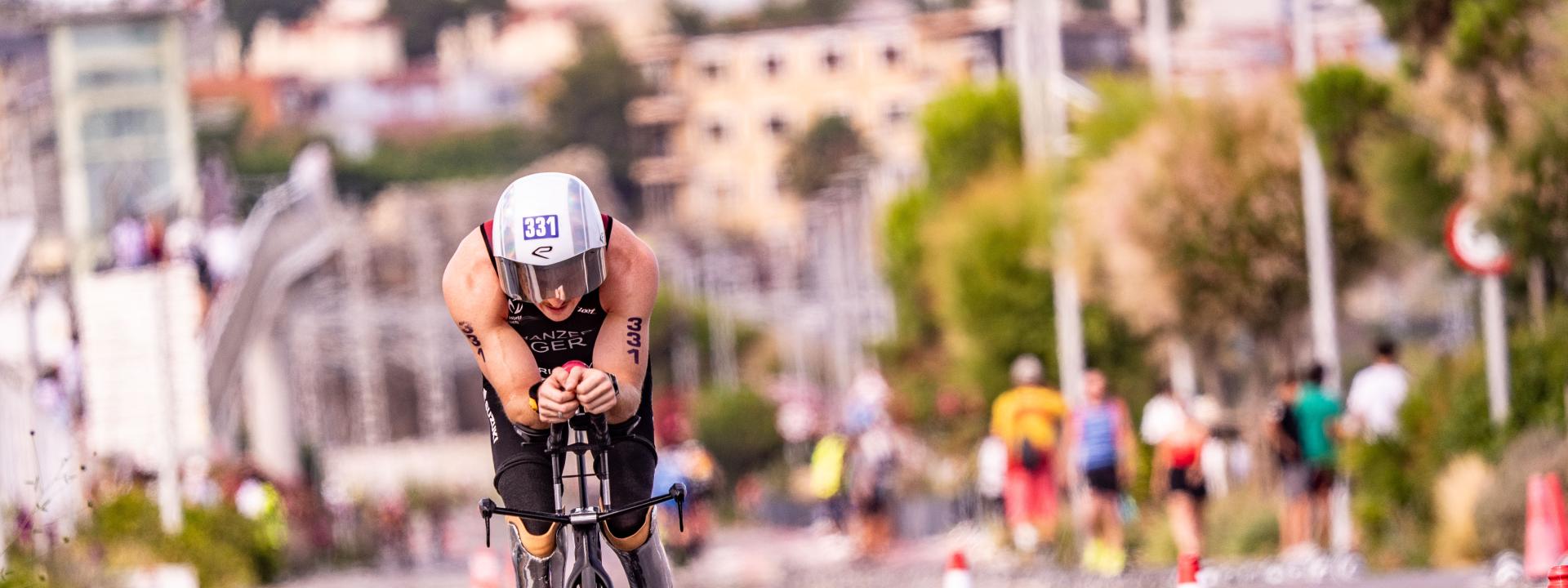 Ein Para Triathlet fährt mit dem Rad auf der Straße auf die Kamera zu