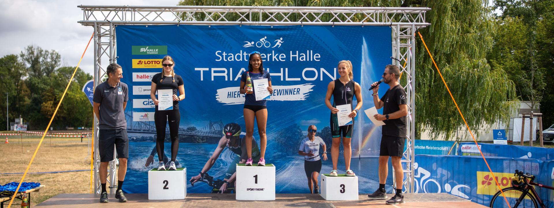 Drei Frauen stehen auf dem Podium 