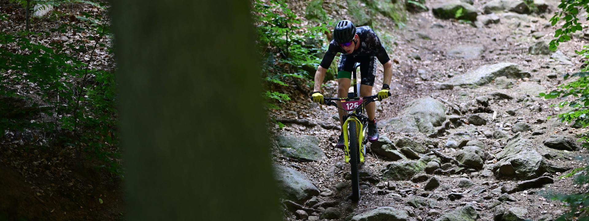 Mann fährt mit MTB durch den Wald 