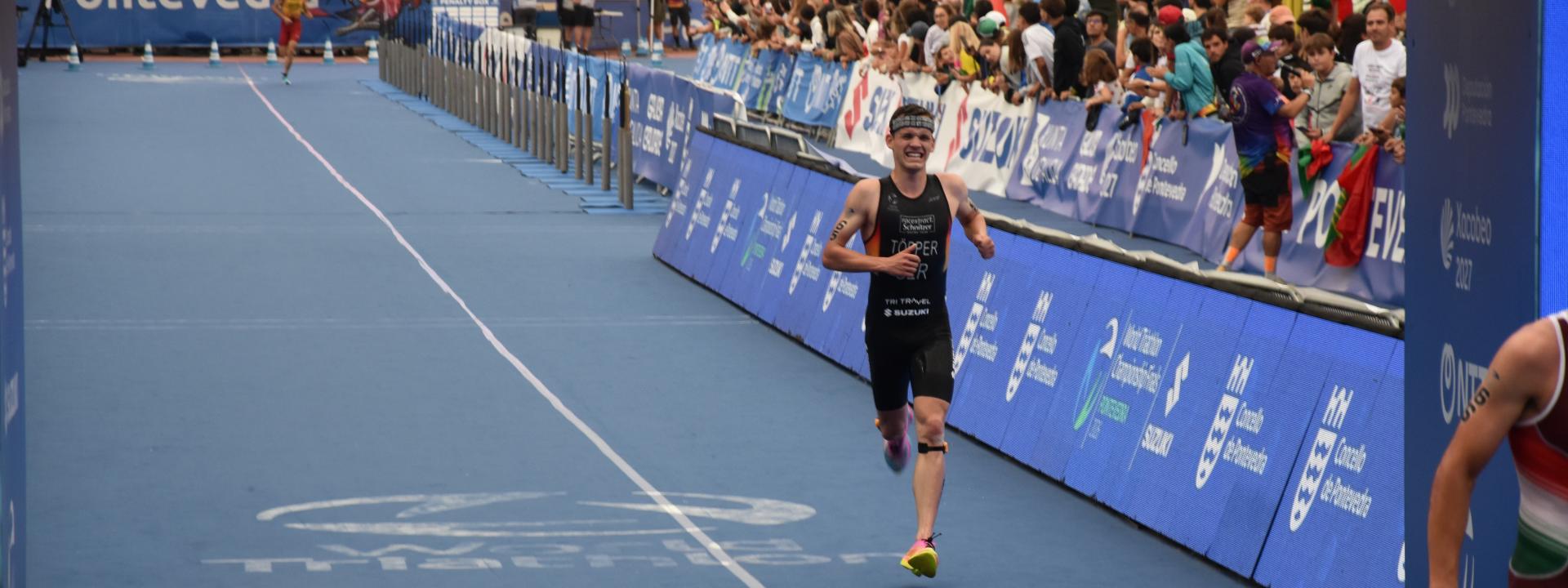 Ein Triathlet läuft bei einem Rennen die letzten Meter ins Ziel