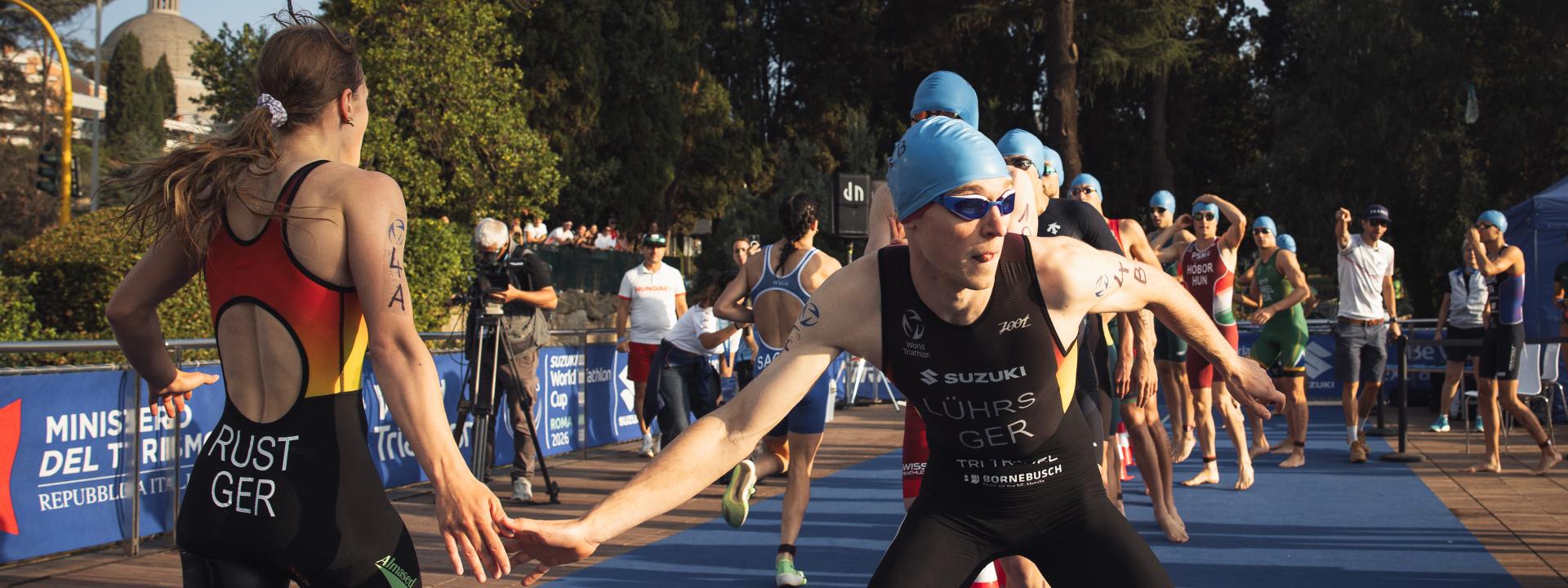 Eine Triathletin schlägt in einem Mixed-Staffel-Rennen mit dem nachfolgenden Triathleten ab