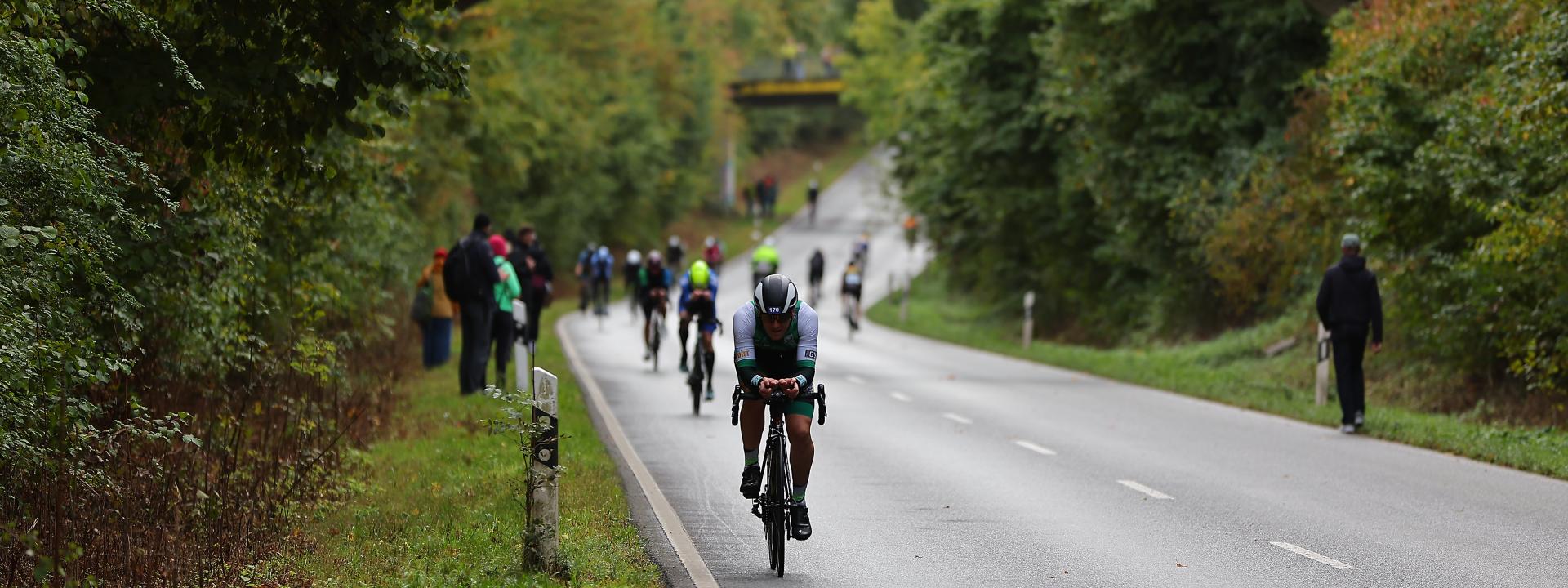 Radfahrer bei einem Wettkampf auf der Brücke Zuschauer