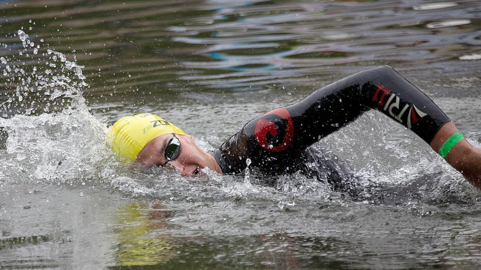 Ein schwimmender Sportler im offenen Gewässer.