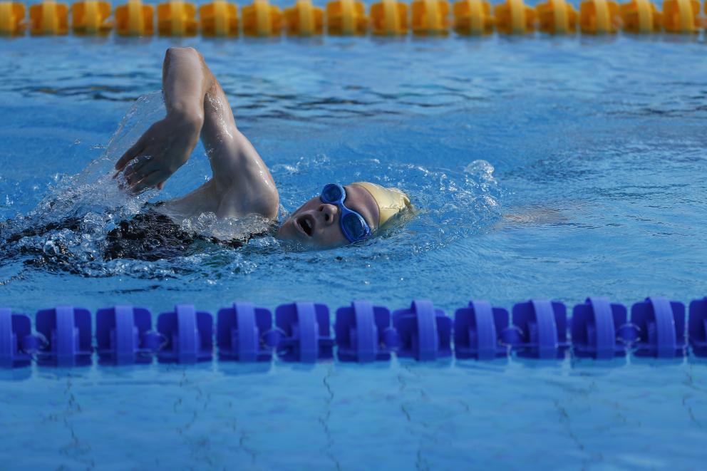 Junger Aktiver beim Kraulschwimmen im Freibad