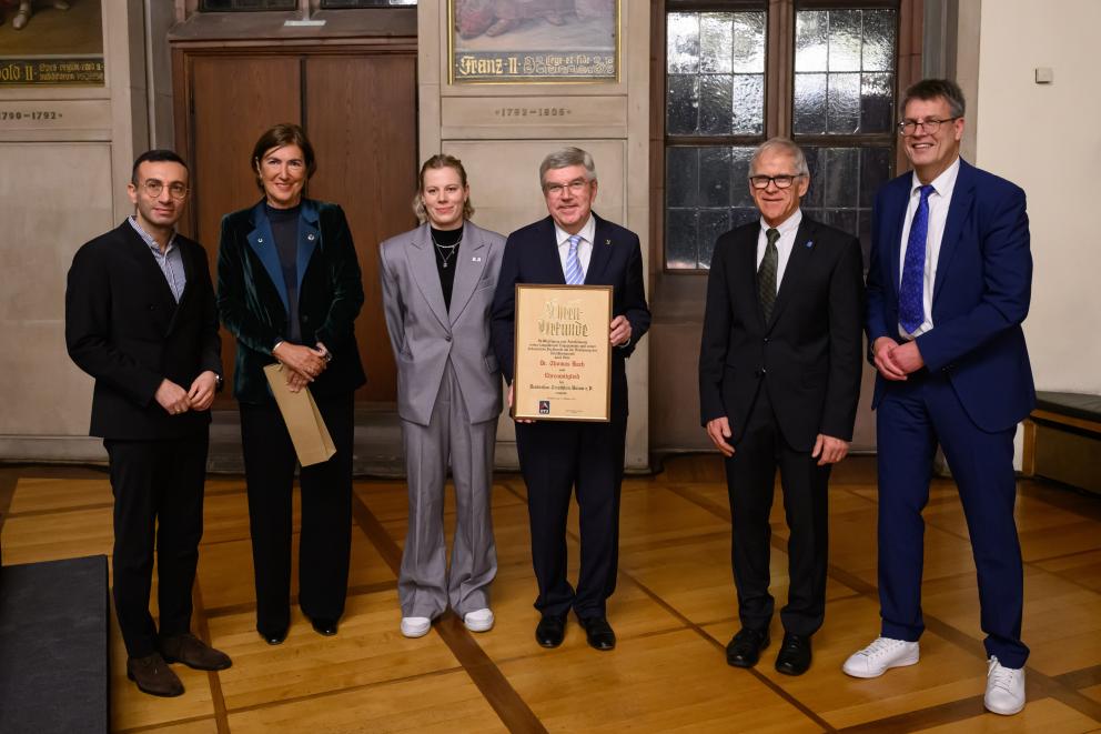 Ein Mann präsentiert eine Urkunde, neben ihm stehen andere Personen