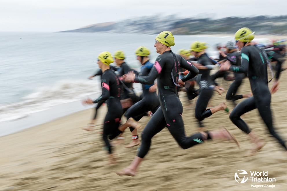 Frauen in einem Neoprenanzug rennen ins Meer