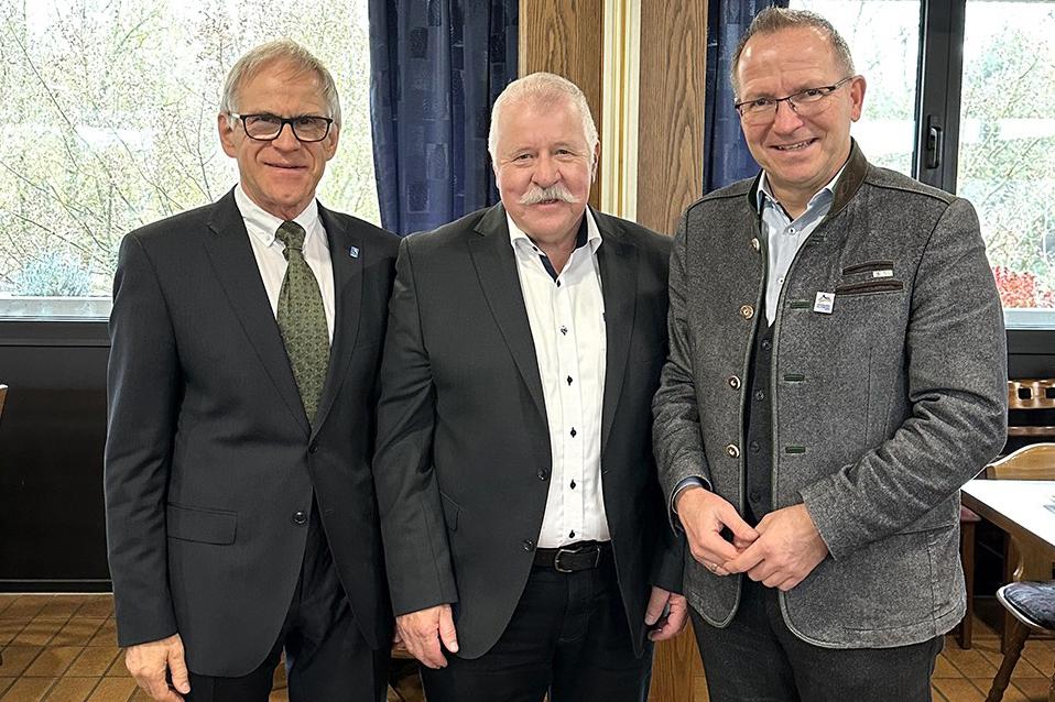 Drei ältere Männer posieren nebeneinander für ein Foto