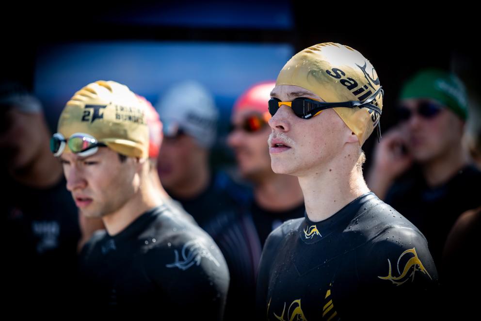 zwei junge Männer mit goldener Badekappe und Schwimmbrille