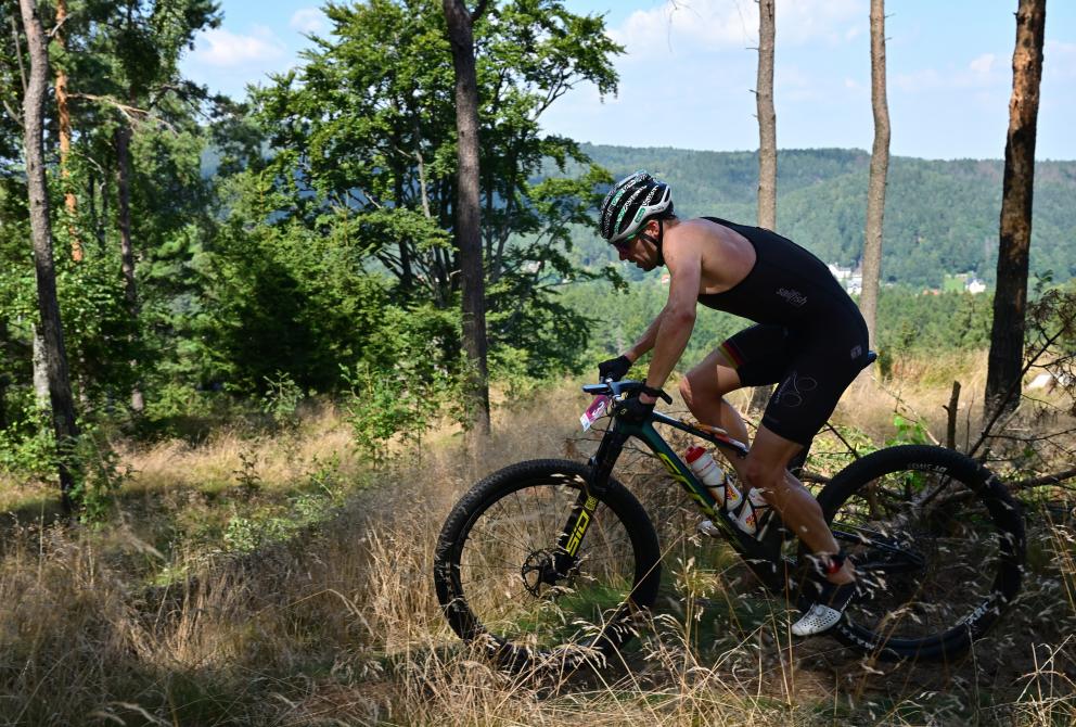 Ein Athlet fährt auf einem Mountainbike durch einen Wald