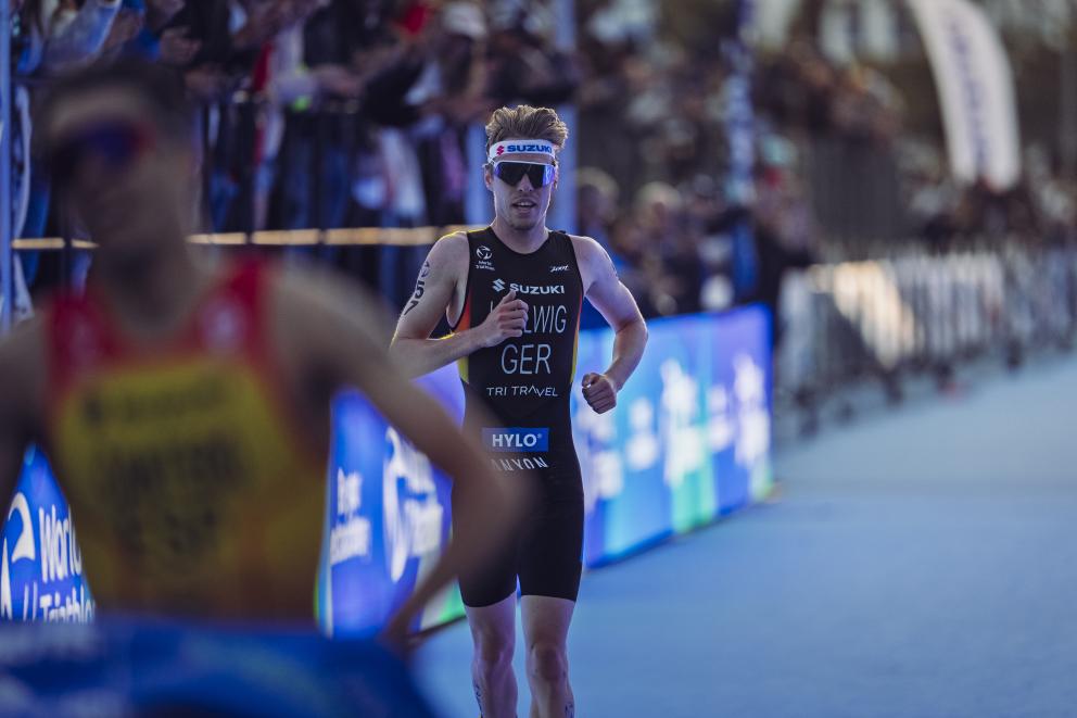 Ein Triathlet läuft über den Zielteppich ins Ziel eines Rennens