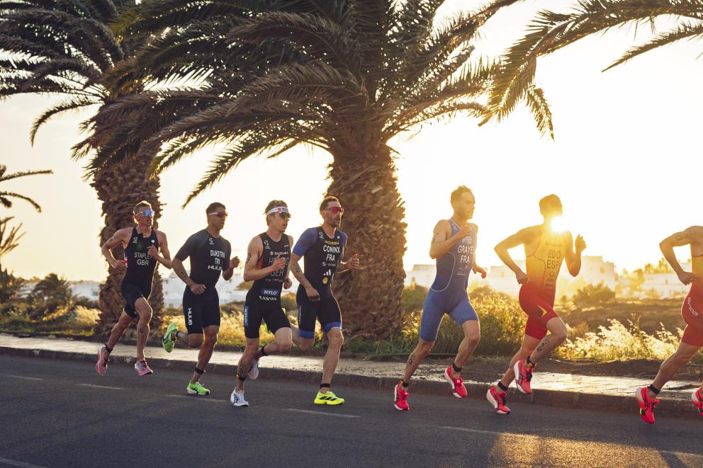 Gruppe Läufer darin auch Hellwig auf der Laufstrecke, im Hintergrund geht die Sonne unter