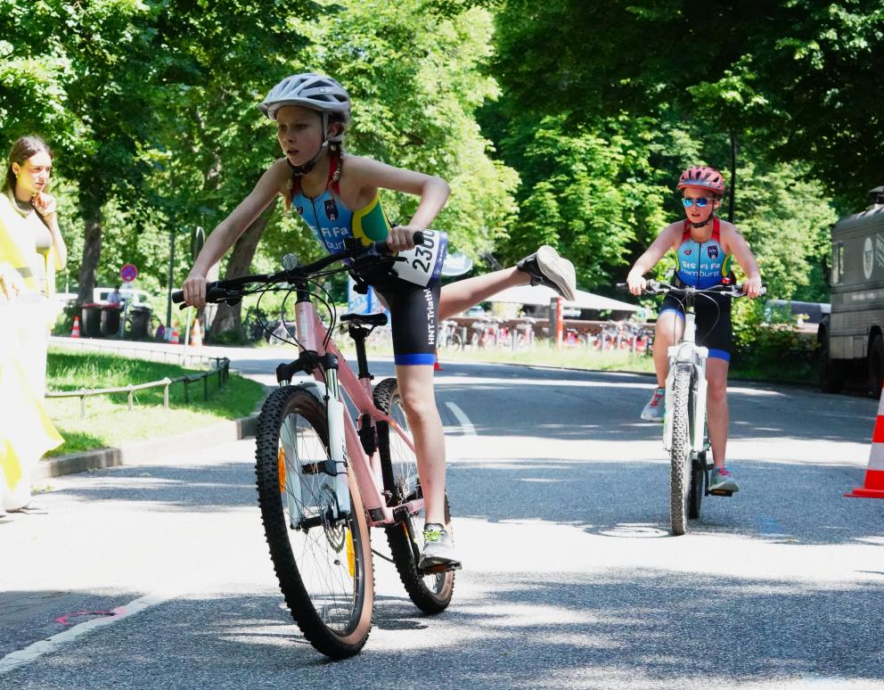 Mädchen steigt am Beginn der Wechselzone vom Fahrrad 