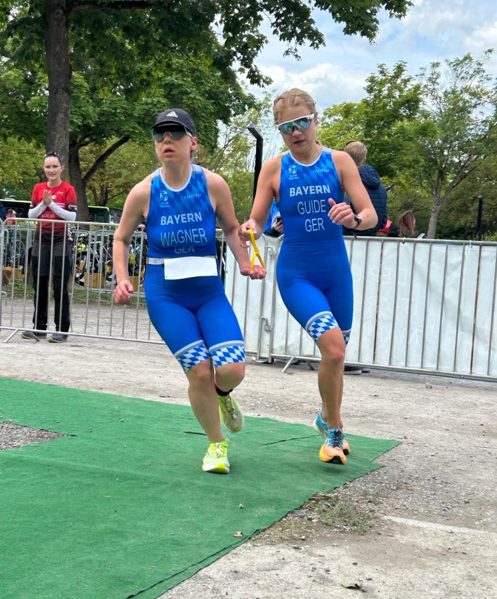 Eine sehbehinderte Triathletin läuft gemeinsam mit ihrer Guide eine Rechtskurve