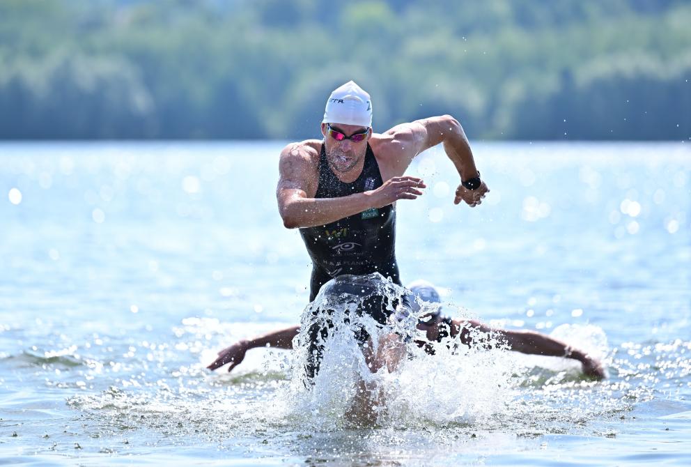 Athlet kommt aus dem See gelaufen 