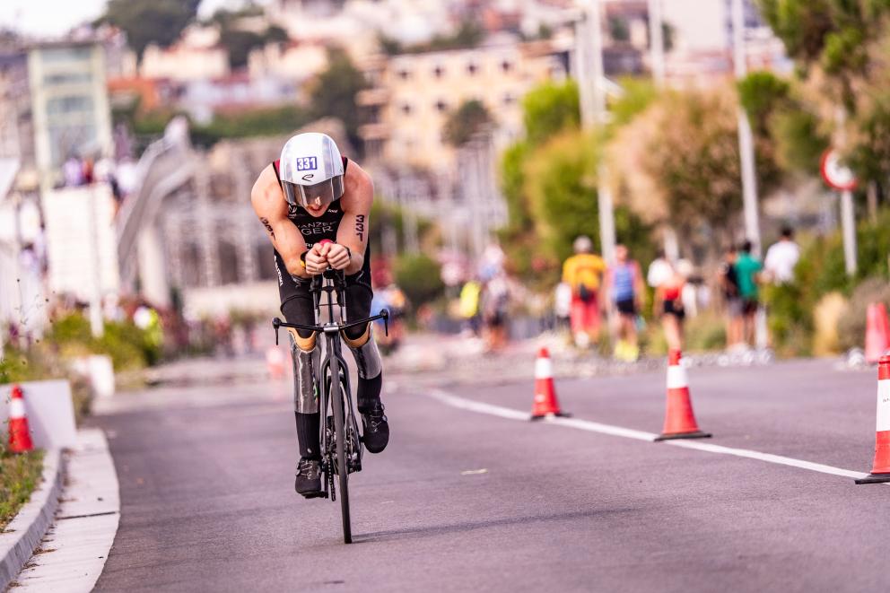 Ein Para Triathlet fährt mit dem Rad auf der Straße auf die Kamera zu