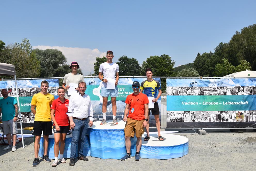 Männer stehen auf einem Podium und Veranstalter davor