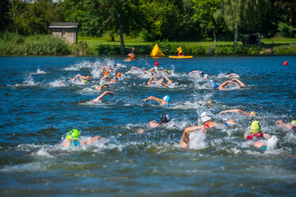 Junge Athleten schwimmen bei einem Triathlon im Wasser