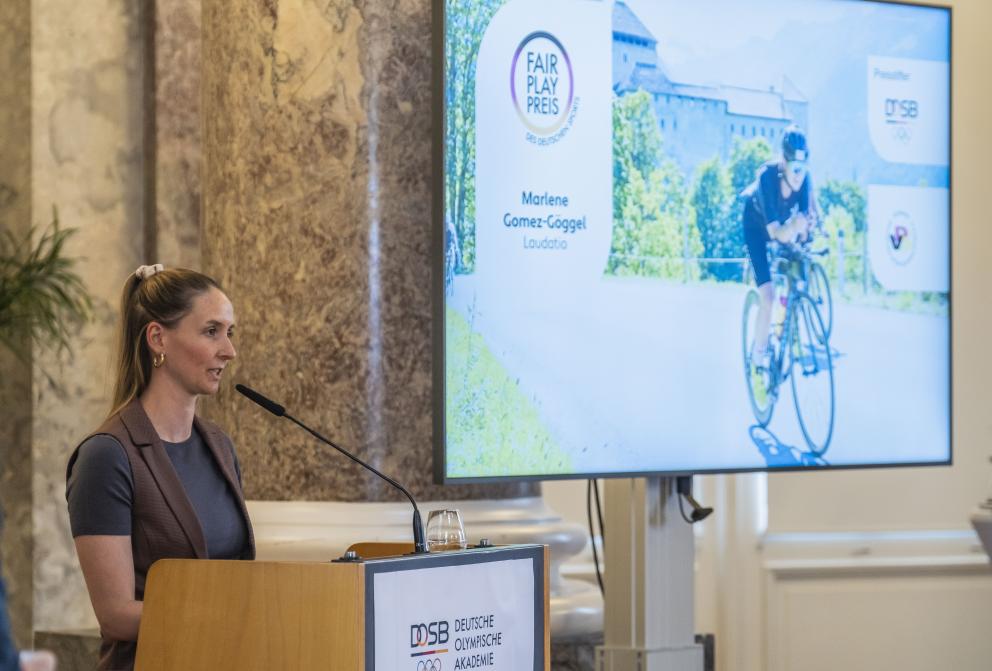 Frau steht vor Rednerpult und hält Laudatio