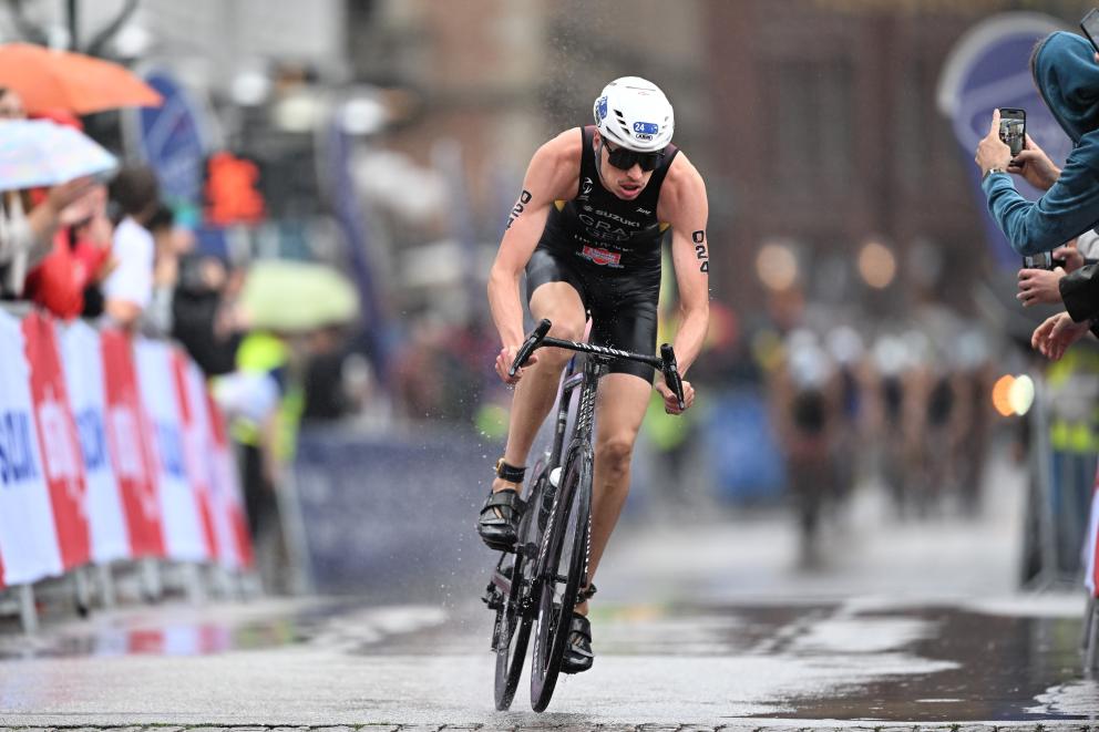 Ein Triathlet fährt auf dem Rad durch Regen