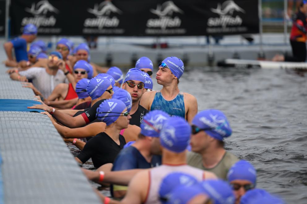 Athleten halten sich am Ponton fest kurz vorm Start