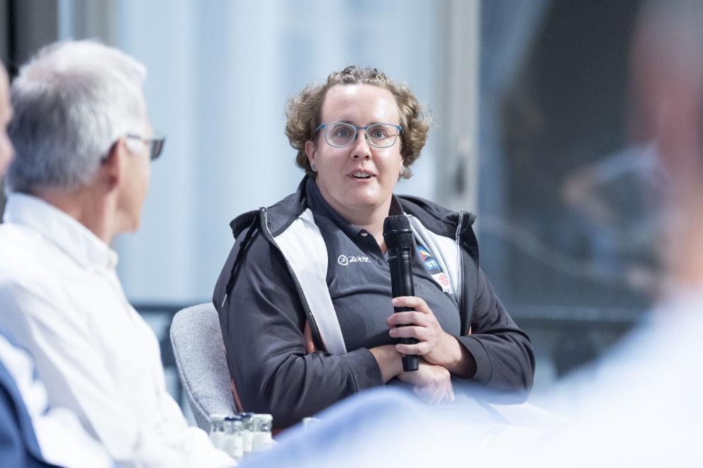 Eine Frau spricht im Rahmen einer Pressekonferenz in ein Mikrofon