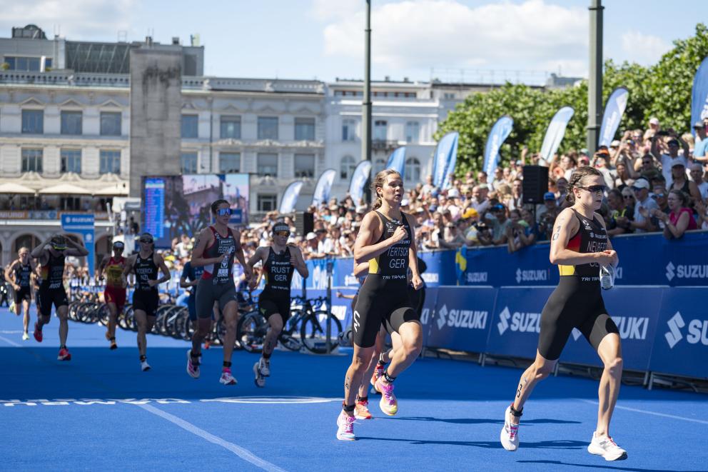 Mehrere Frauen laufen bei einem Triathlon aus der Wechselzone