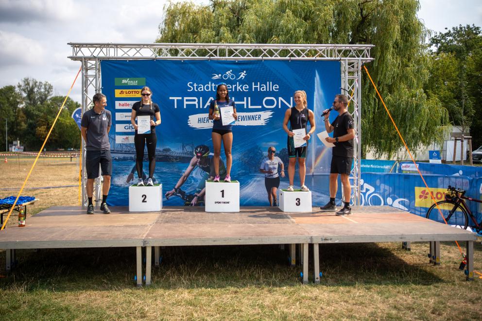 Drei Frauen stehen auf dem Podium 