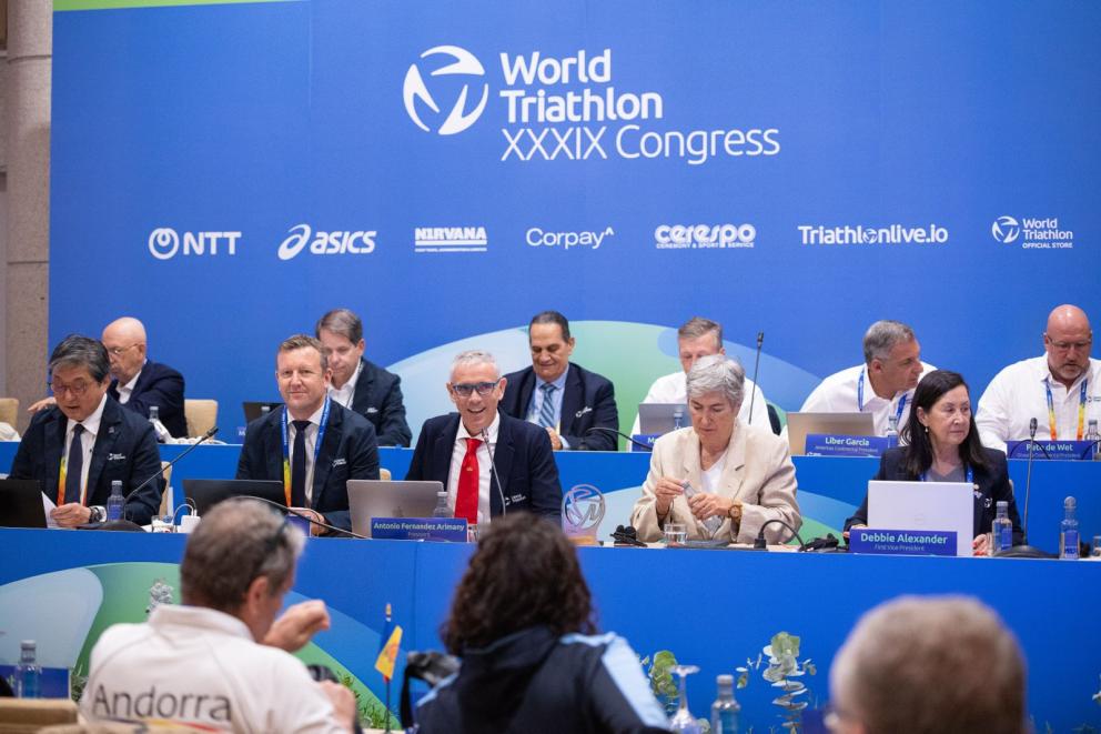 Mehrere Menschen sitzen im Rahmen einer Tagung zusammen in einem Kongress-Saal