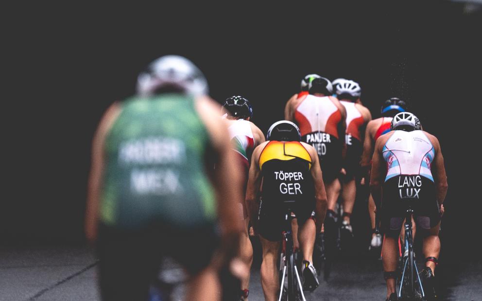 Mehrere Triathleten in der Rückansicht auf der Radstrecke