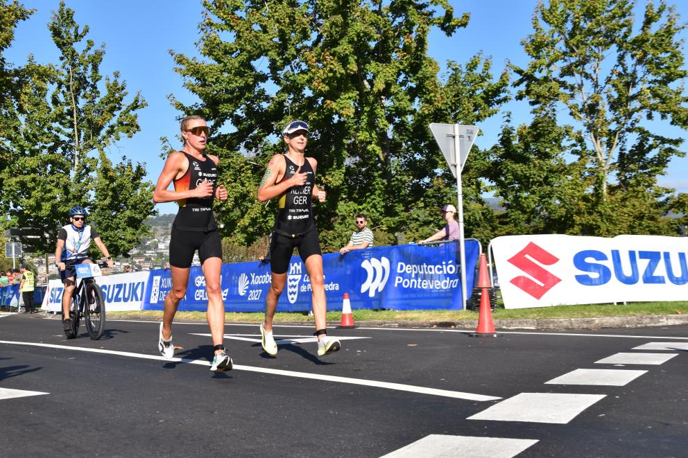 Eine sehbeeinträchtigte Para Triathletin läuft gemeinsam mit ihrem Guide auf der Laufstrecke eines Para Triathlons