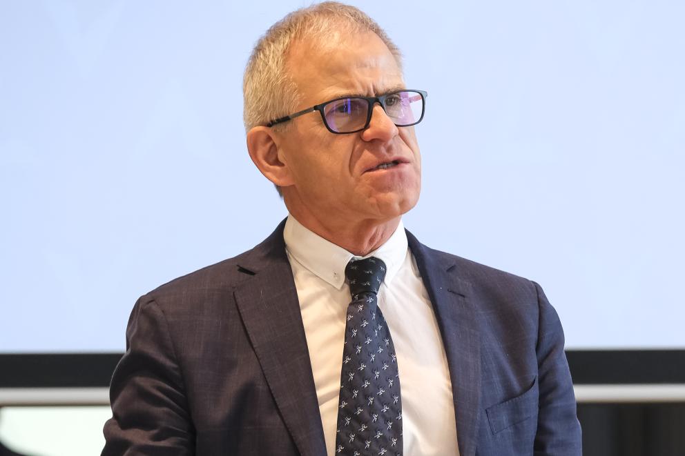 Ein Portrait eines älteren Mannes in Anzug, der eine Brille trägt