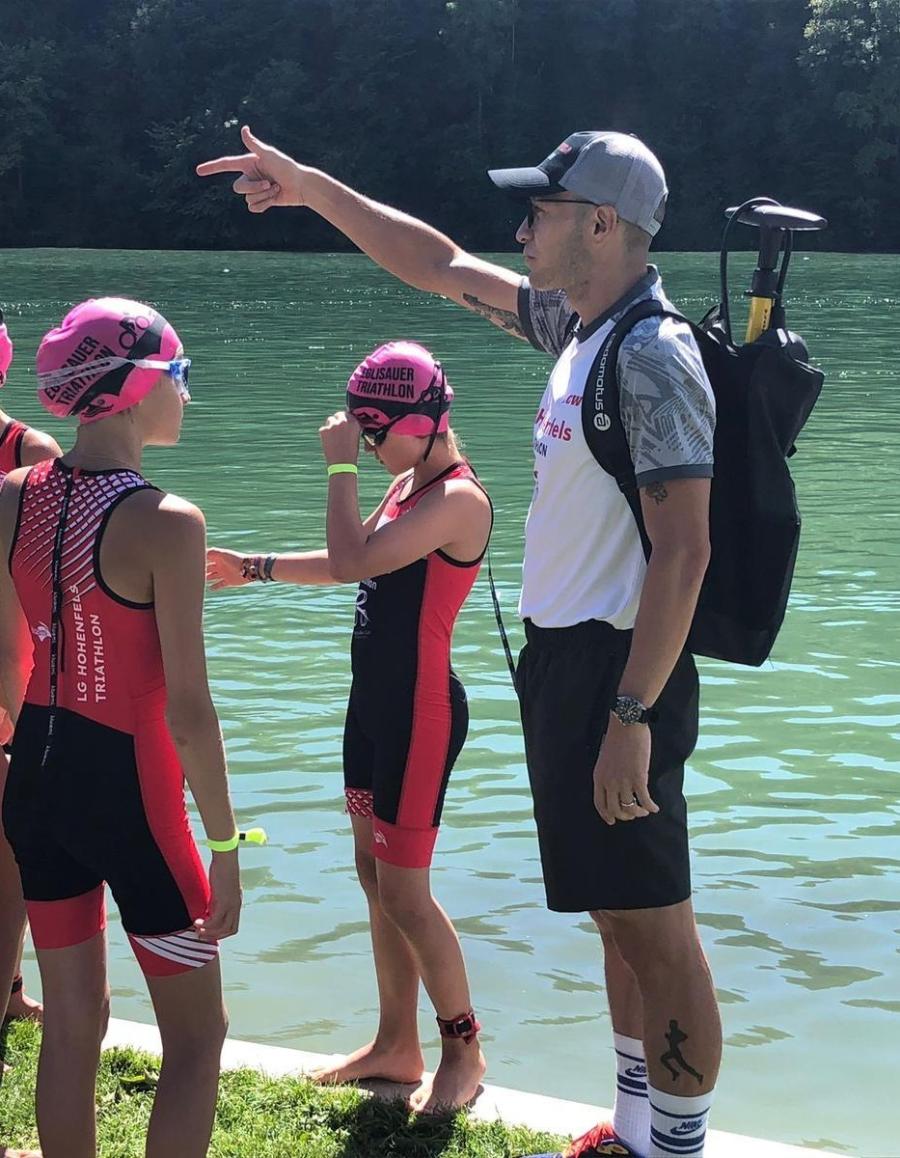 Trainer am Wasser mit jungen Athleten