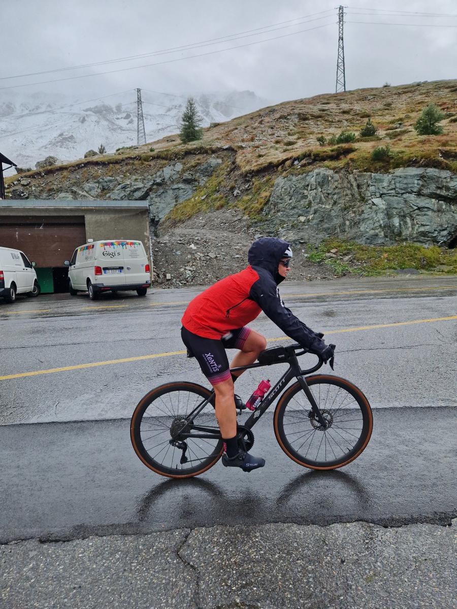 Frau in Regenjacke bei schlechtem Wetter auf dem Rennrad