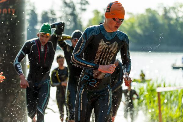 Jugendliche kommen im Neo aus dem Wasser und laufen zur Wechselzone beim DTU Jugend Cup 2023 Forst
