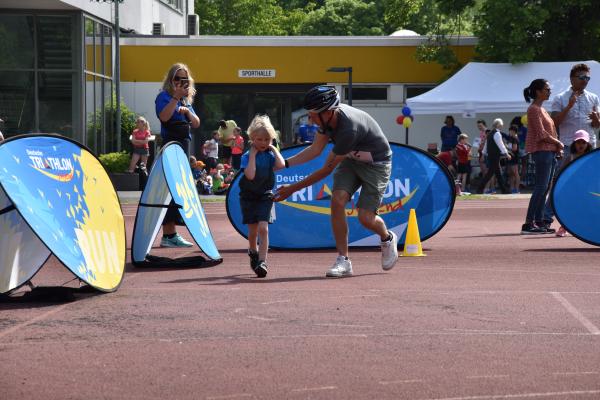 Mann hilft Kind während des Laufens