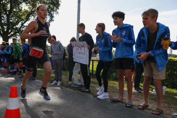 Jugendliche wird beim Laufen von anderen angefeuert