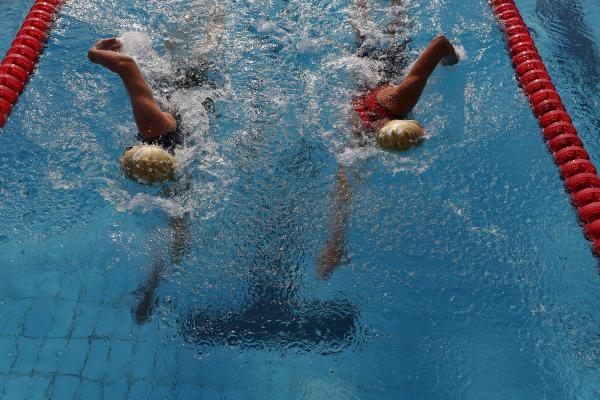 zwei Jugendliche beim Kraulschwimmen im Becken