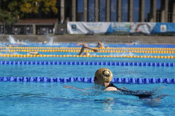 Brustschwimmerin vorn im Bild, im Hintergrund Kraulschwimmer