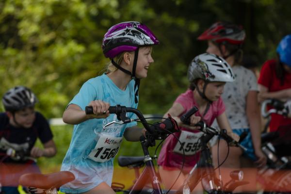 Zwei Mädchen lachen und schieben ihre Räder
