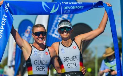 Zwei Sportlerinnen jubeln gemeinsam im Ziel mit dem Zielband über ihren Sieg